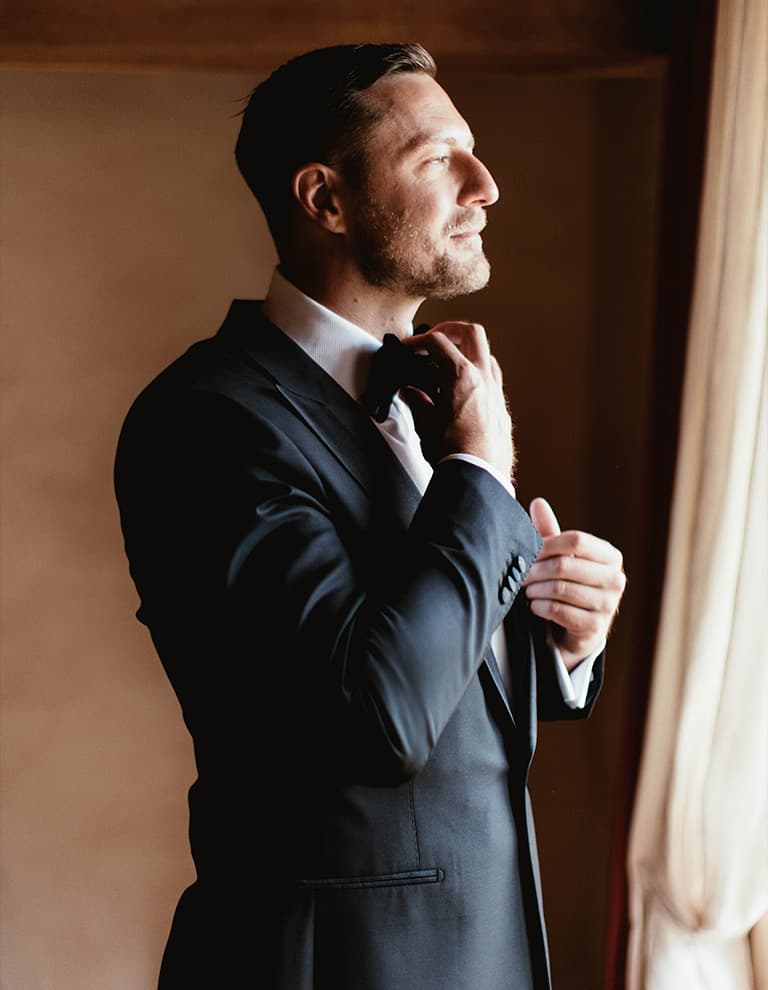 groom preparing for black tie wedding