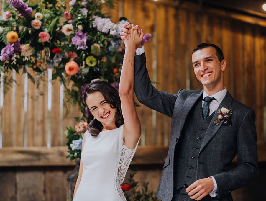 bride and groom celebrate hand in hand