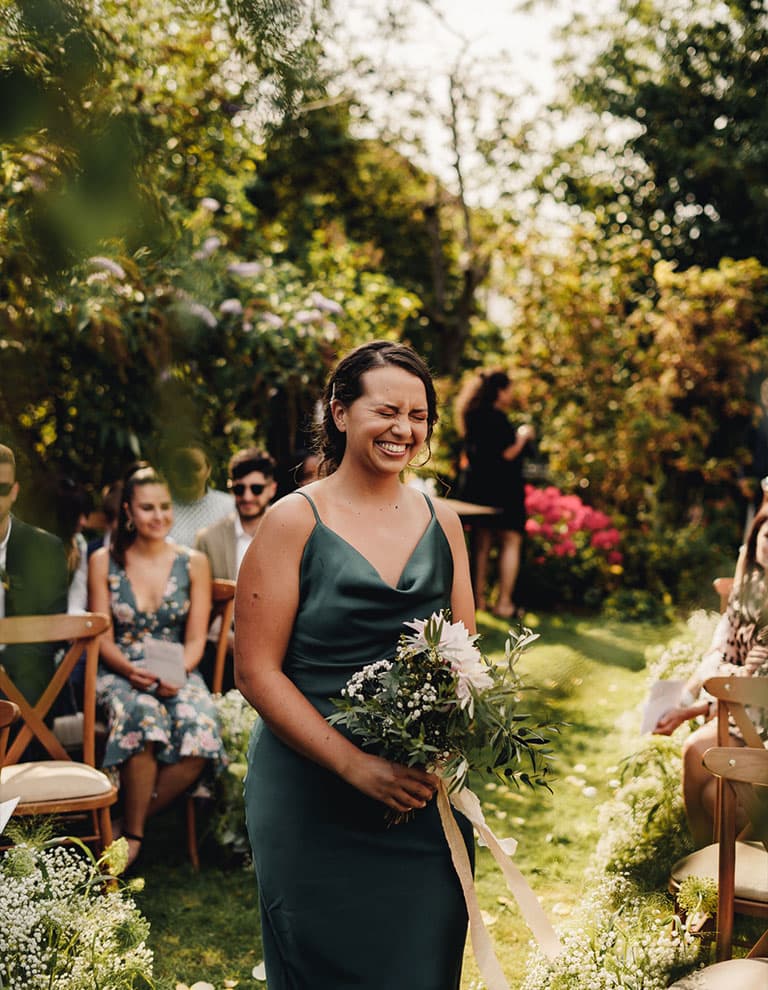 bridesmaid with flower bouquet in emerald green dress