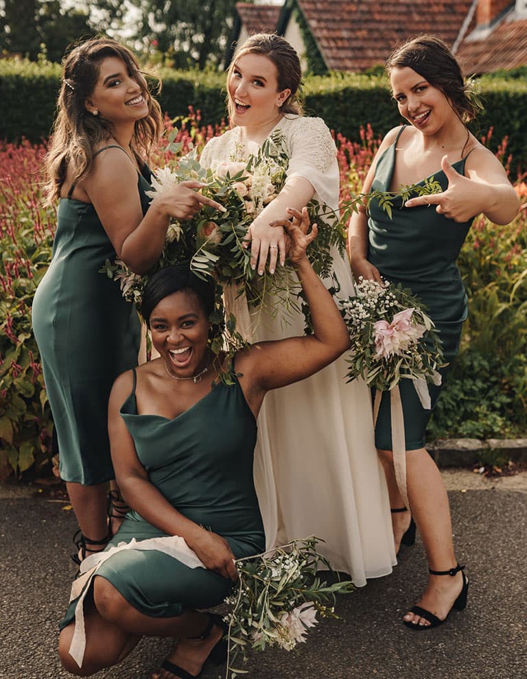 bride and bridesmaids holding flower bouquets