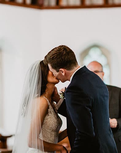 bride and groom share kiss after vows in the church