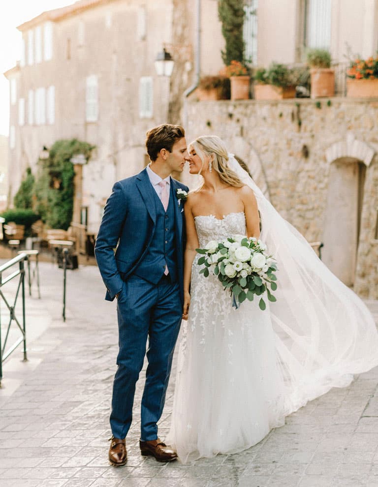 Sequel wedding: bride and groom kiss in front of medieval walls of their wedding venue