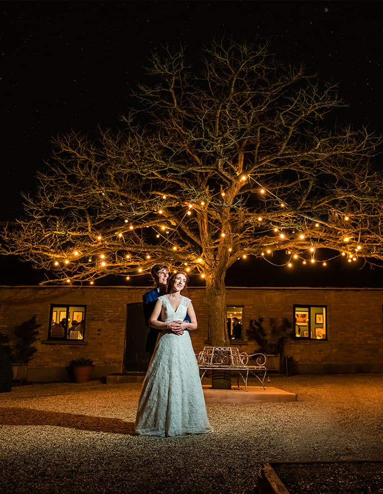 Claudia & Daniel under a night lit tree