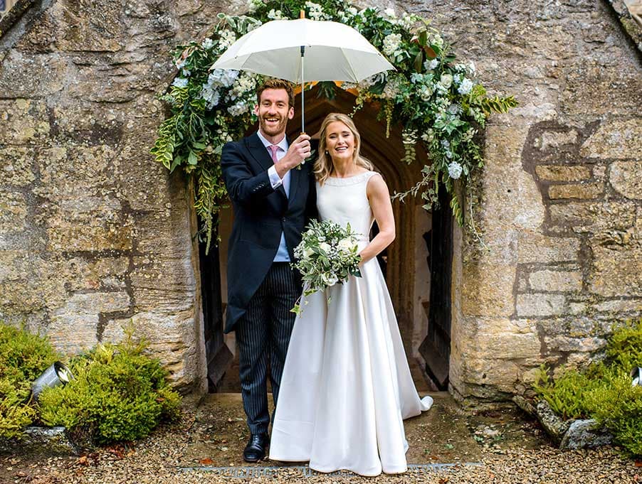 married couple in front of archway of church entrance
