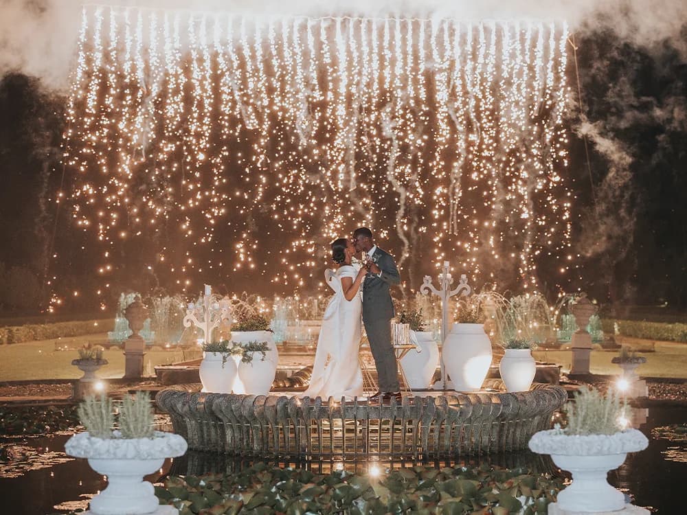 Bride and groom under fireworks outside the wedding venue