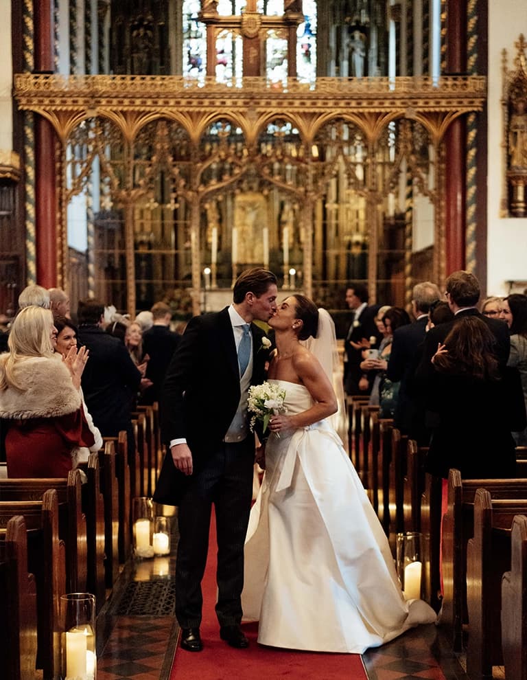Kimberly and James kiss while walking down the aisle