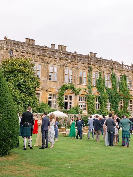 Wedding guests mingling outside the wedding venue, Brymton House