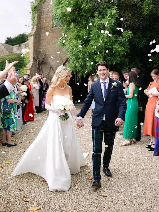 Bride and groom enjoy confetti after leaving the wedding ceremony