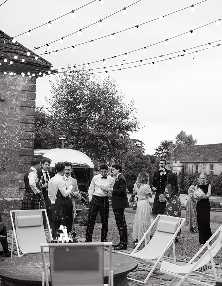 wedding guests next to fire pit at Brympton House