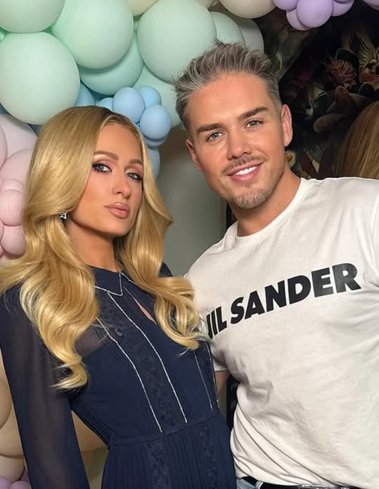 Paris Hilton and Buster Knight standing together in front of pastel balloons