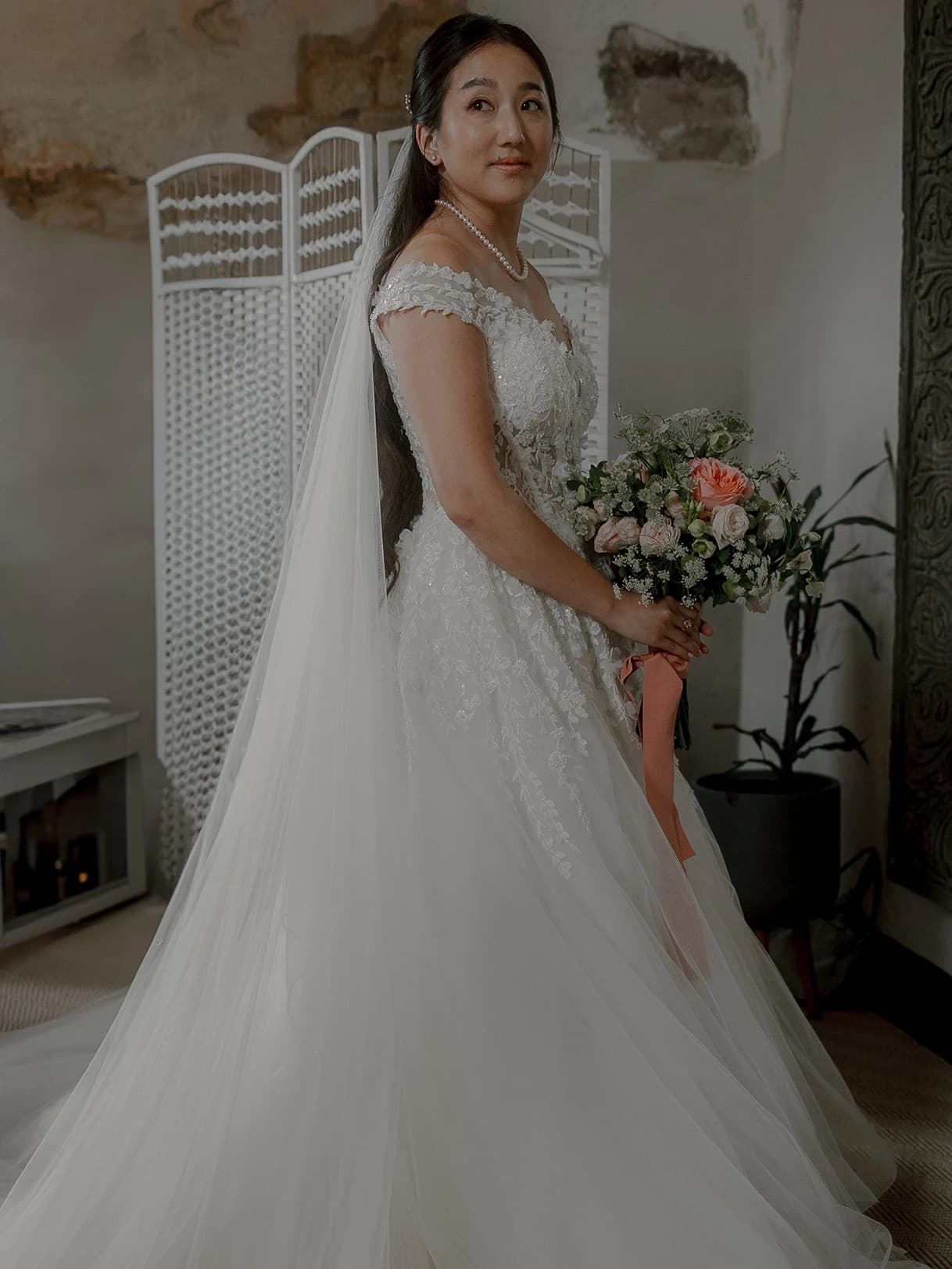 Bride wearing a gown with applique and also a long veil