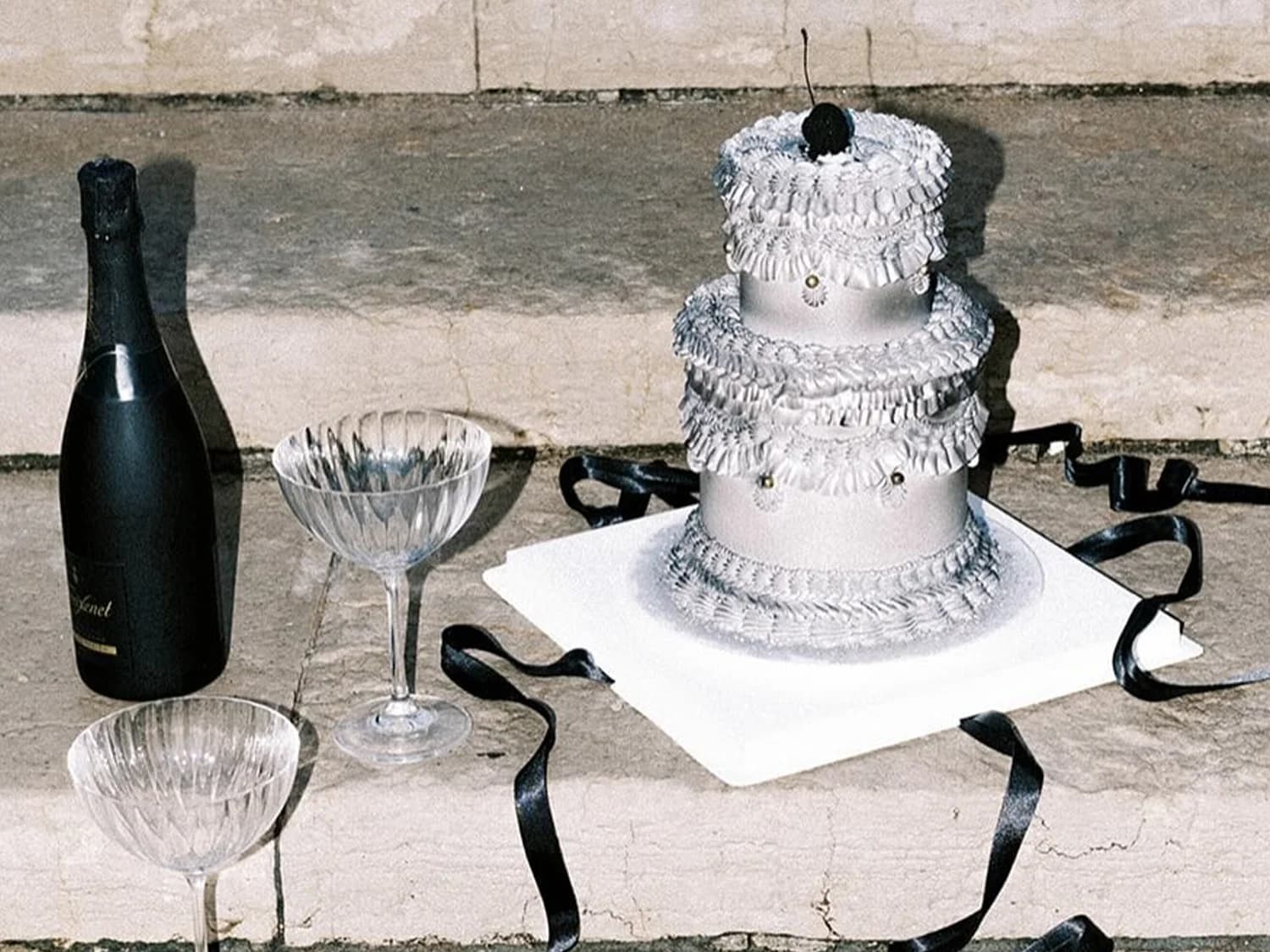 A gothic-inspired tiered cake with icing and bows
