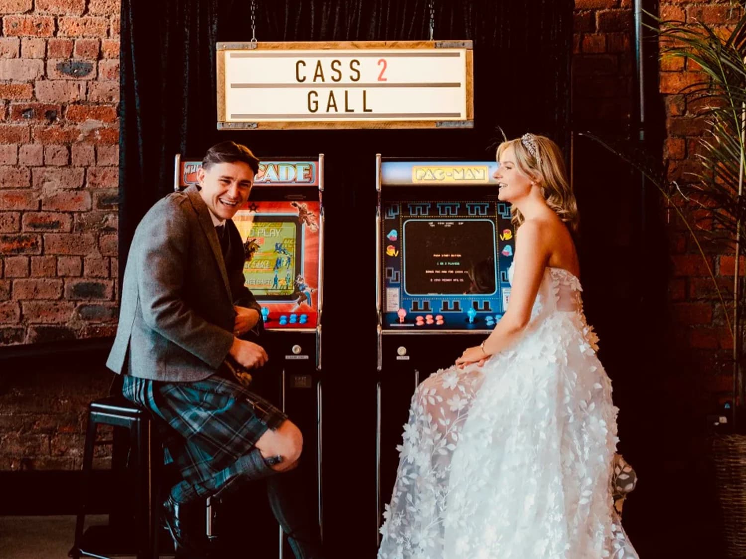 Bride and groom enjoy arcade games at the wedding