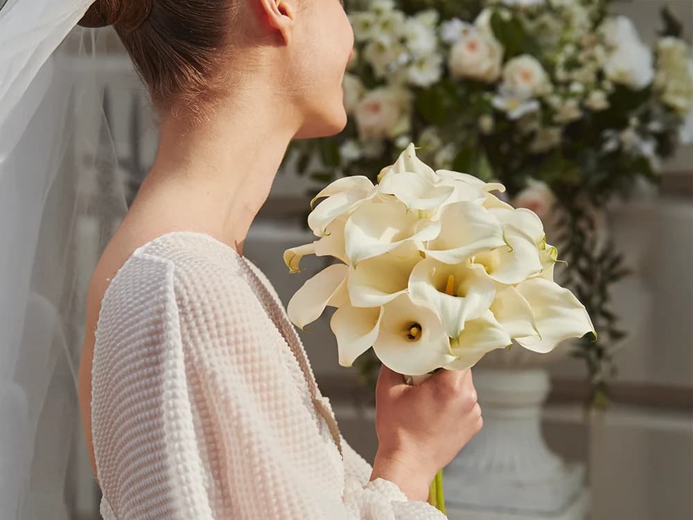 A bride holds a bouquet from long stem flowers