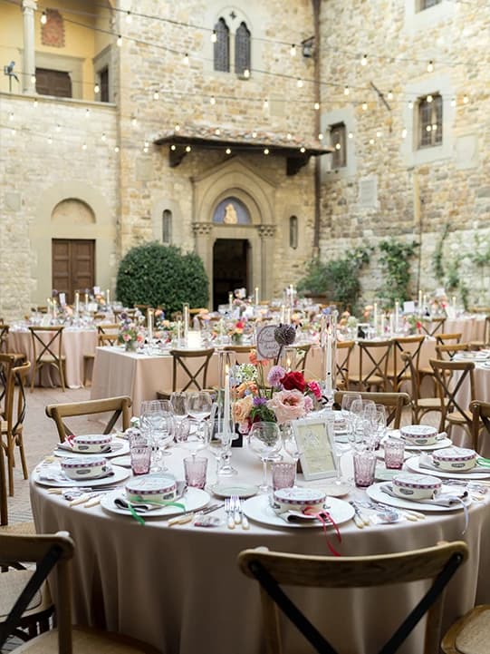 Destination wedding reception tables inside old stone building