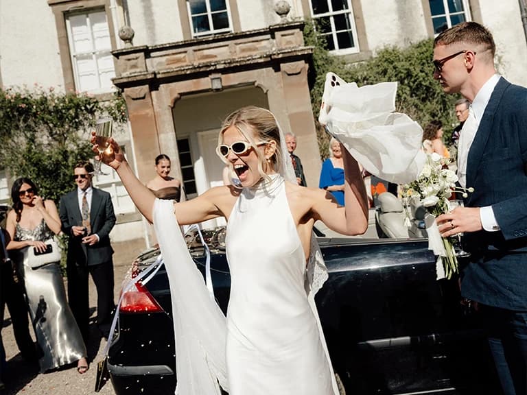 Newlyweds celebrating outside a historic family estate in Scotland