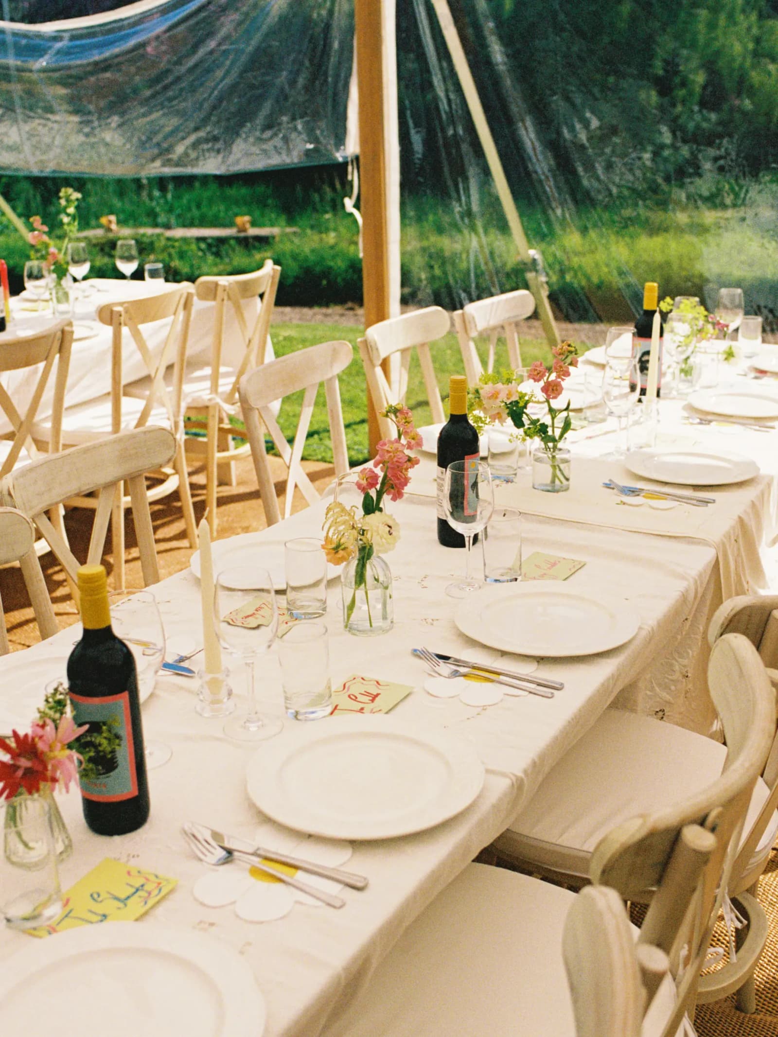 Marquee wedding tables with white linen, local garden flowers, red wine and cross-back chairs at Middleton House, Scotland